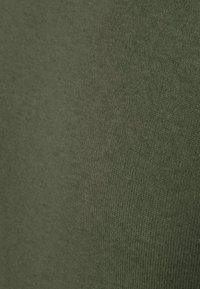 Olijfgroene stof, zachte textuur, medium gewicht, met een subtiele ribbelpatroon. Gedetailleerde close-up focus op het oppervlak van het materiaal.