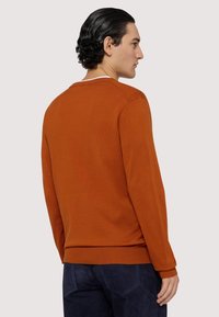 Oranger, strukturierter Pullover mit Rundhalsausschnitt und gerippten Bündchen. Das Design zeichnet sich durch eine einfarbige Optik und einen lässigen Schnitt aus, der sich ideal für die Freizeitkleidung eignet.