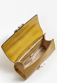 Yellow crocodile-embossed leather handbag with a snap closure. Features a spacious interior and a zipped pocket for organization.