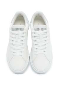 Zapatillas de cuero blancas con cordones planos blancos, detalles en plata brillante en la lengüeta y un acabado plateado texturizado en el collar.