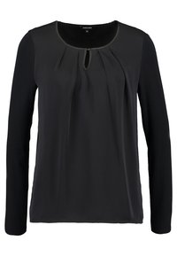 Blusa nera a maniche lunghe con scollatura rotonda, dettaglio plissettato sul davanti e accentuata apertura a chiave. Realizzata in un tessuto leggero e morbido.