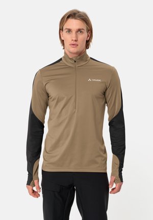 Camisa deportiva de manga larga para hombre con torso beige y mangas negras, hecha de tejido elástico con cuello de media cremallera y detalle del logo.