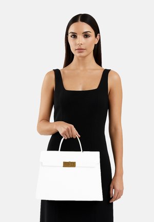 Borsa strutturata bianca con chiusura in oro, dotata di manico superiore e una texture liscia. Esibita con un modello in un abito nero.