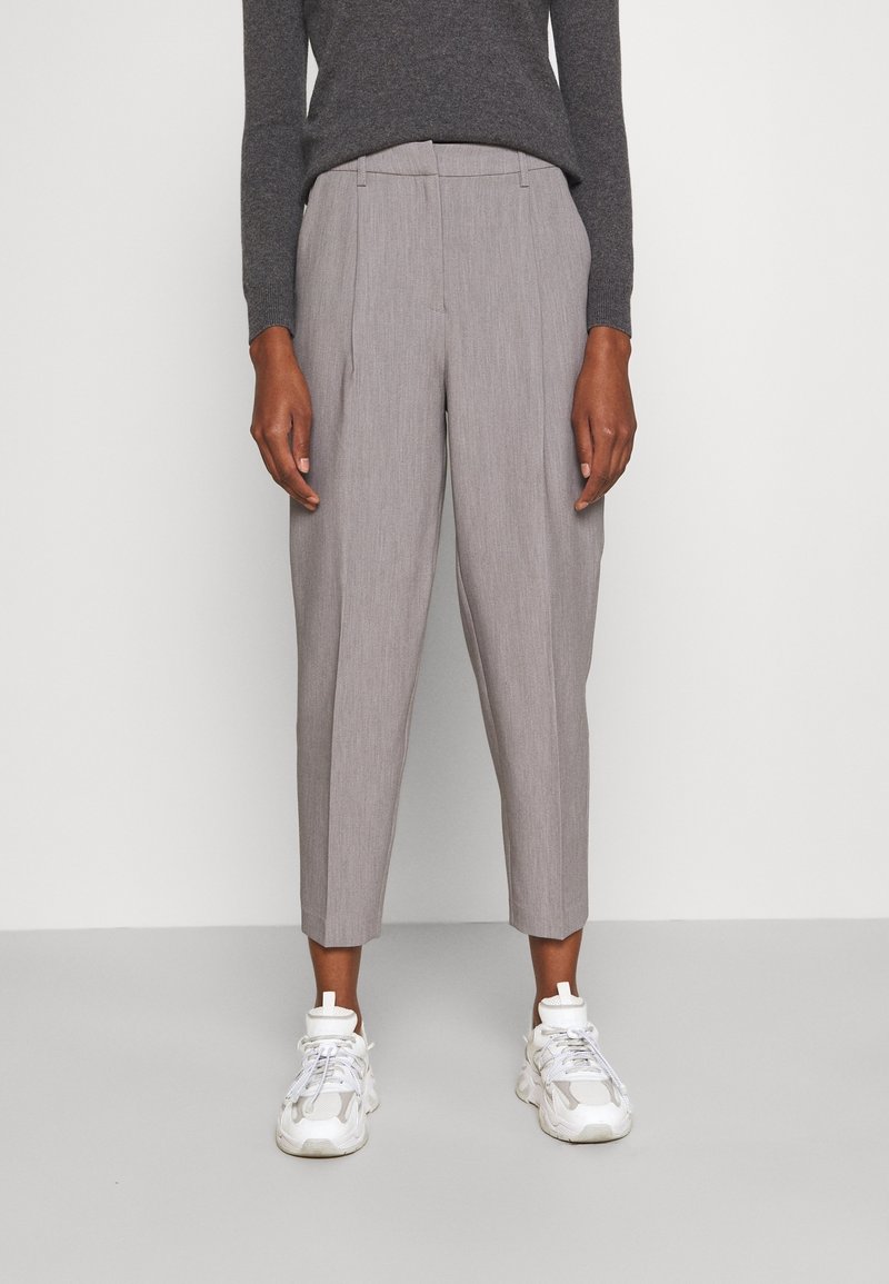 Szare spodnie w prążki o dopasowanym kroju, z mid-rise talią, zwężanymi nogawkami i plisowanymi detalami, zestawione z białymi trampkami.