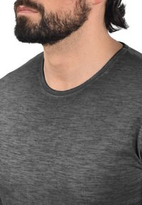 Charcoal grå crewneck t-shirt lavet af blødt, struktureret stof med et subtilt marl-mønster. Figurtilpasset design med en glat halsudskæring.