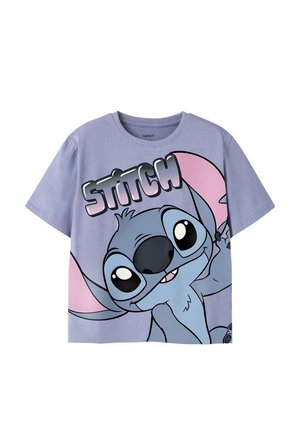 Chemise lilas à manches courtes avec un grand personnage de dessin animé Stitch aux oreilles roses et le mot "STITCH" en lettres majuscules au-dessus.