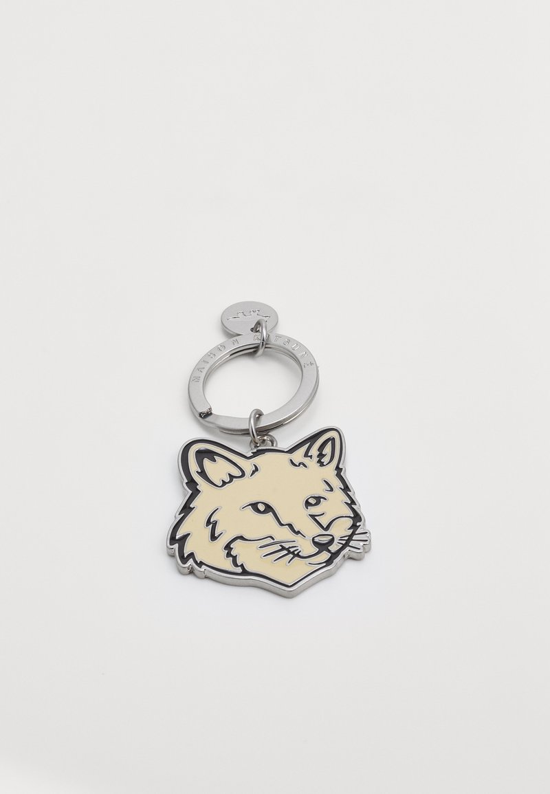 Keychain featuring a fox head design in light beige enamel with black outlines, attached to a silver metal ring with a small tag.