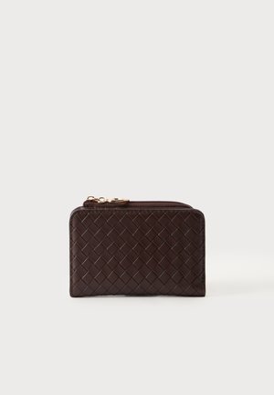 Portefeuille en cuir marron foncé avec texture tissée, forme rectangulaire et fermeture éclair double ton doré en haut sur un fond clair uni.