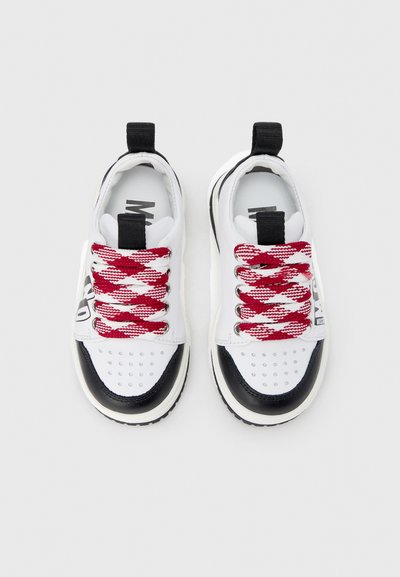 Άσπρα αθλητικά παπούτσια με μαύρες λεπτομέρειες και κορδόνια με ριγέ κόκκινο και άσπρο. Διαθέτουν στρογγυλές τρύπες στη μύτη και θηλιά στην φτέρνα.
