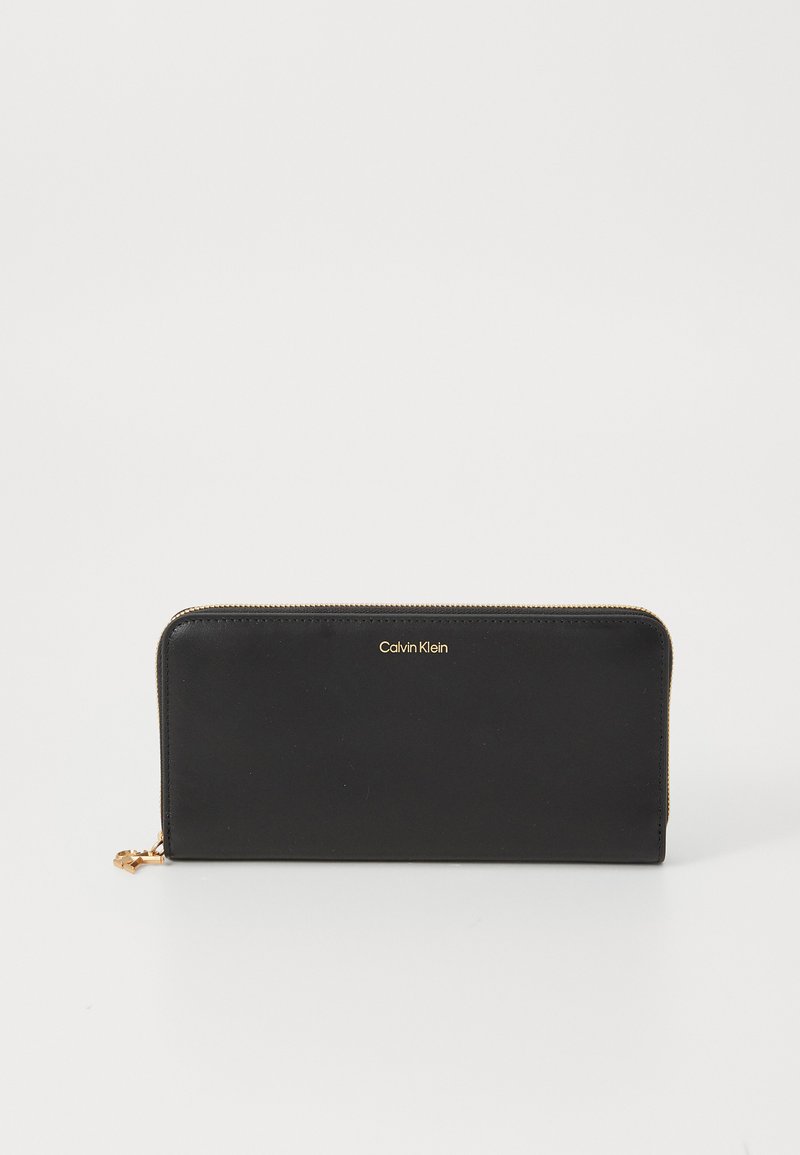 Portefeuille en cuir noir avec quincaillerie dorée, fermeture à glissière et logo embossé. Dispose d'une forme rectangulaire élégante et d'une texture lisse.