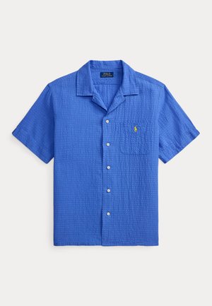 Chemise bleue à manches courtes avec boutons, col camp, poche poitrine et logo Polo Ralph Lauren jaune brodé.