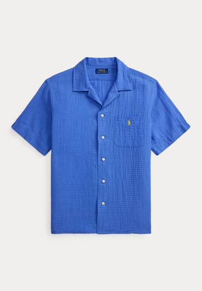 Chemise bleue à manches courtes avec boutons, col camp, poche poitrine et logo Polo Ralph Lauren jaune brodé.