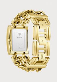 Gold stainless steel watch with a rectangular case, interconnected chain link strap, and a white watch face displaying the Guess logo.