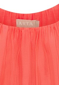 Koralfarvet bluse med plisseret tekstur. Rundet halsudskæring med et mærke, der tydeligt viser "MARTA" ved kraven.