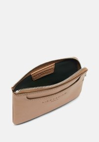 Skórzana torba w kolorze tan, z zamknięciem na zamek błyskawiczny, z czarnym podszewką i wytłoczonym logo. Elegancki, smukły kształt o zaokrąglonym wyglądzie.