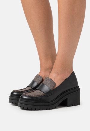 Mocassins en cuir noir avec un dessus texturé marron, semelle plateforme épaisse et large sangle sur le cou-de-pied pour un maintien sécurisé.