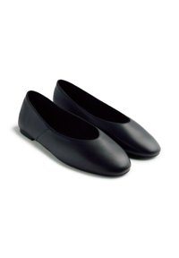 Bailarinas negras hechas de cuero suave, con puntera redonda y tacón bajo. Diseño sencillo sin patrones o adornos visibles.