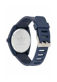 Sinine silikoonist randme kell roostevabast terasest tagaküljega, millel on logo, ümmargune korpus ja ventilatsiooniks mõeldud sälguga disain.