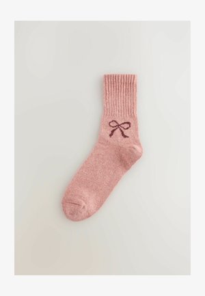 Roosa puuvillane sokk ribatatud mansetiga, millel on tumeroosa sõlme graafika. Pehme tekstuur ja pahkluuni ulatuv disain.