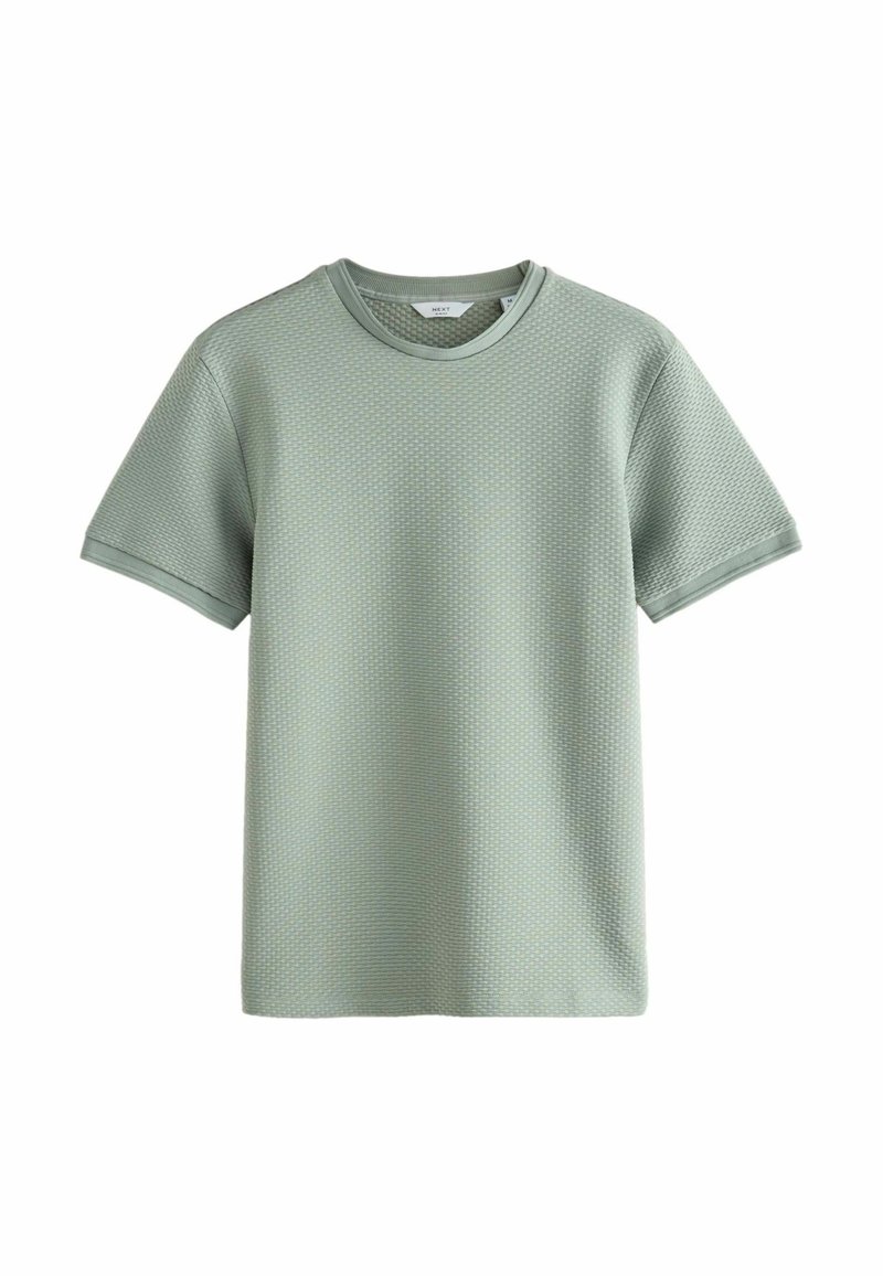 T-shirt à manches courtes vert clair en tricot texturé avec col rond et un motif tissé subtil, présenté sur un fond blanc.