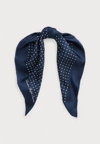 Tengerészkék selyemsál fehér pöttyökkel, sima textúrával és a tetején csomóval. Egyik oldalán díszes, kurzív felirattal.