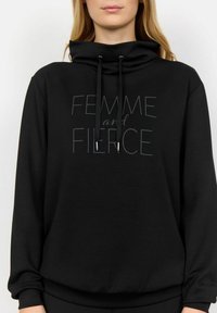 Felpa nera con cappuccio e collo alto, dotata di coulisse e un design testuale stampato in colori più chiari sul davanti. Il testo recita "FEMME e FIERCE."