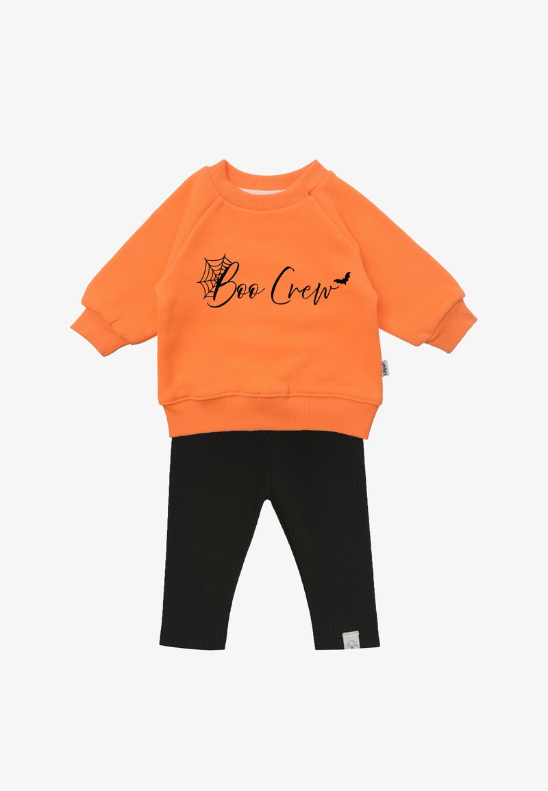 Orange sweatshirt with "Boo Crew" text, black spiderweb and bat motifs. Paired with black ribbed leggings, soft fabric, casual fit.
