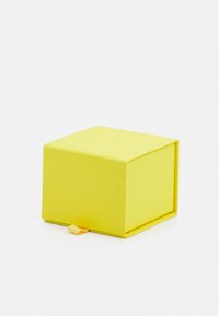 Caja cuadrada amarilla hecha de papel texturizado, con una pestaña para abrir. El color es brillante y los bordes son limpios y nítidos.