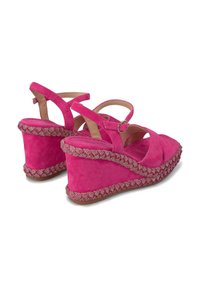 Roze suede wedge sandalen met kruisslingerende bandjes en een textuur, gevlochten wedge hak. Beschikt over een verstelbare enkelband en een zachte voetbed.