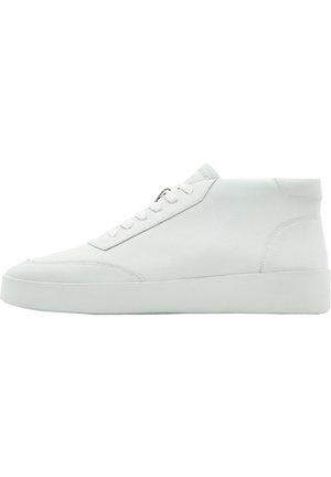 Baskets mid-top blanches avec lacets à l'avant, surface en cuir lisse et semelle épaisse, présentées de profil sur fond blanc.