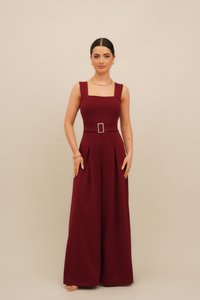 Burgundské overaly s hranatým výstrihom, voľnými nohavicami a záhybmi, so pásom a striebornou sponou. Hladká, hrubá tkanina.