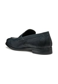Mocassino in pelle nera con punta arrotondata, dettagli cuciti, tacco basso e superficie strutturata. Design slip-on con interno morbido.