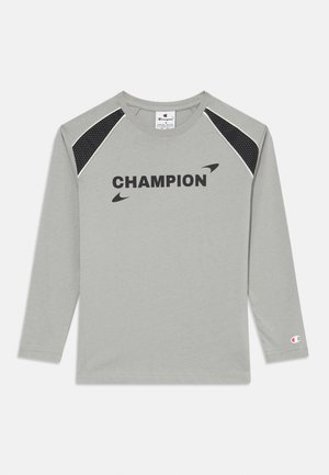 Graues Langarmshirt mit einem schwarzen "CHAMPION"-Logo, schwarzen Mesh-Akzenten an den Schultern und einem kleinen Logo am rechten Ärmel.