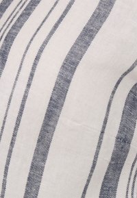 Tecido de algodão com listras verticais alternadas em azul marinho e branco, com um acabamento texturizado e superfície lisa.