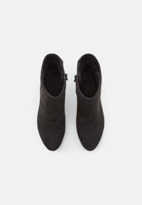 Zwarte enkellaarsjes van suede met een gladde afwerking, puntige neus, zijkanten met ritsen en lage gestapelde hakken.