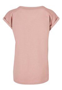 Kortermet, lys rosa t-skjorte med rund hals og rullede ermer. Mykt, lett stoff med en jevn tekstur. Enkelt design.