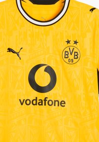 Κίτρινη φανέλα ποδοσφαίρου της Borussia Dortmund με μαύρα λογότυπα Puma, χορηγό Vodafone και δύο μαύρα αστέρια πάνω από το έμβλημα BVB 09.