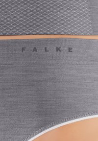 Graue nahtlose Unterwäsche mit strukturierter Oberfläche im Diamantmuster, schwarzes "FALKE"-Logo und kontrastierende weiße Nähte entlang der Ränder.