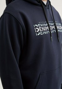 Granatowa bluza z kapturem wykonana z mieszanki bawełny, z kieszenią kangurką, regulowanym sznurkiem i grafiką tekstową z przodu w kontrastujących kolorach.