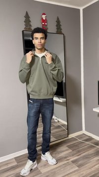 Gray sweatshirt with a white collar and zipper, worn with dark blue jeans and white sneakers; mirror and wall decor in background.