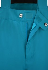 Türkisfarbener Stoff mit verstellbaren Riemen, Druckknopf- und Klettverschlüssen sowie einer Reißverschlussöffnung. Glatte Textur mit verstärkten Nähtelementen.