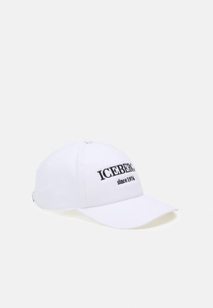 Gorra de béisbol blanca con texto negro "ICEBERG since 1974" bordado en el frente, mostrada contra un fondo claro y liso.