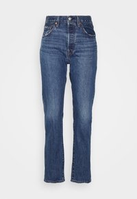 Höga blå jeans av denim med fem fickor, framknappning och raka ben med subtila blekningsdetaljer.