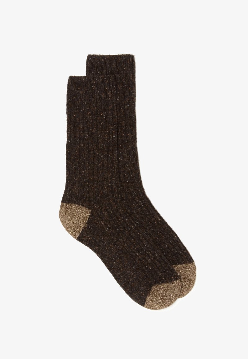 Donkerbruine geribde sokken met een textuurafwerking en gouden accenten bij de hielen en tenen. De stof lijkt warm en duurzaam te zijn.