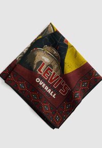 Bandana piegato Levi's con colori rosso, giallo e nero, con stampa di jeans in denim e il testo "Levi's Overall America's Finest Since 1850".