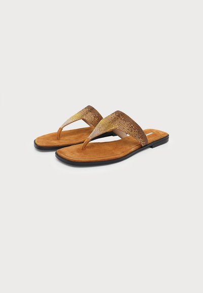 Pair of brown suede flat sandals with black soles and glittery gold thong straps on plain background.