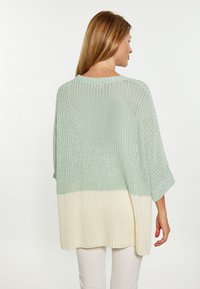 Maglione lavorato a maglia leggero con vestibilità ampia, parte superiore verde che sfuma in crema. Presenta un collo ampio e maniche a tre quarti.