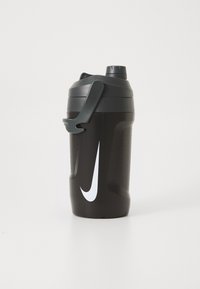 Zwarte plastic shakerfles met een gestructureerde grip, grijze deksel en een wit Nike swoosh-logo. Bevat een veilige handgreep en maatmarkeringen.