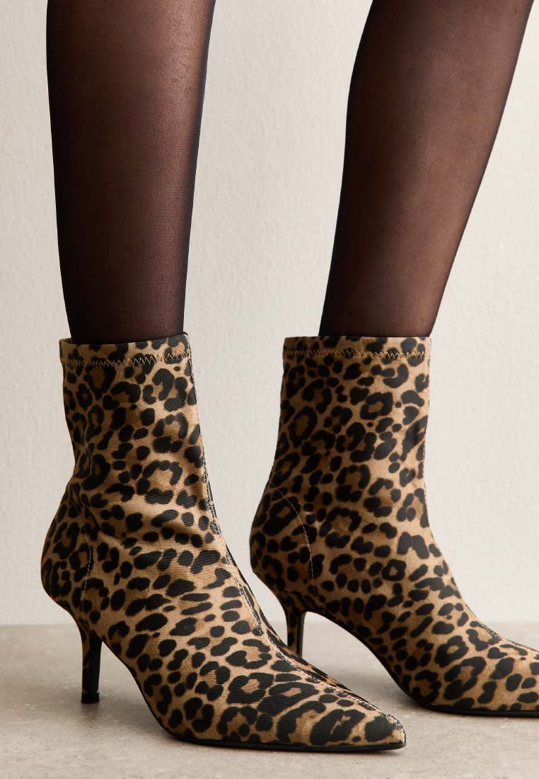 Bottes chevilles imprimé léopard avec bouts pointus et talon fin. Fabriquées en tissu doux à texture lisse, avec un détail subtilement cousu.