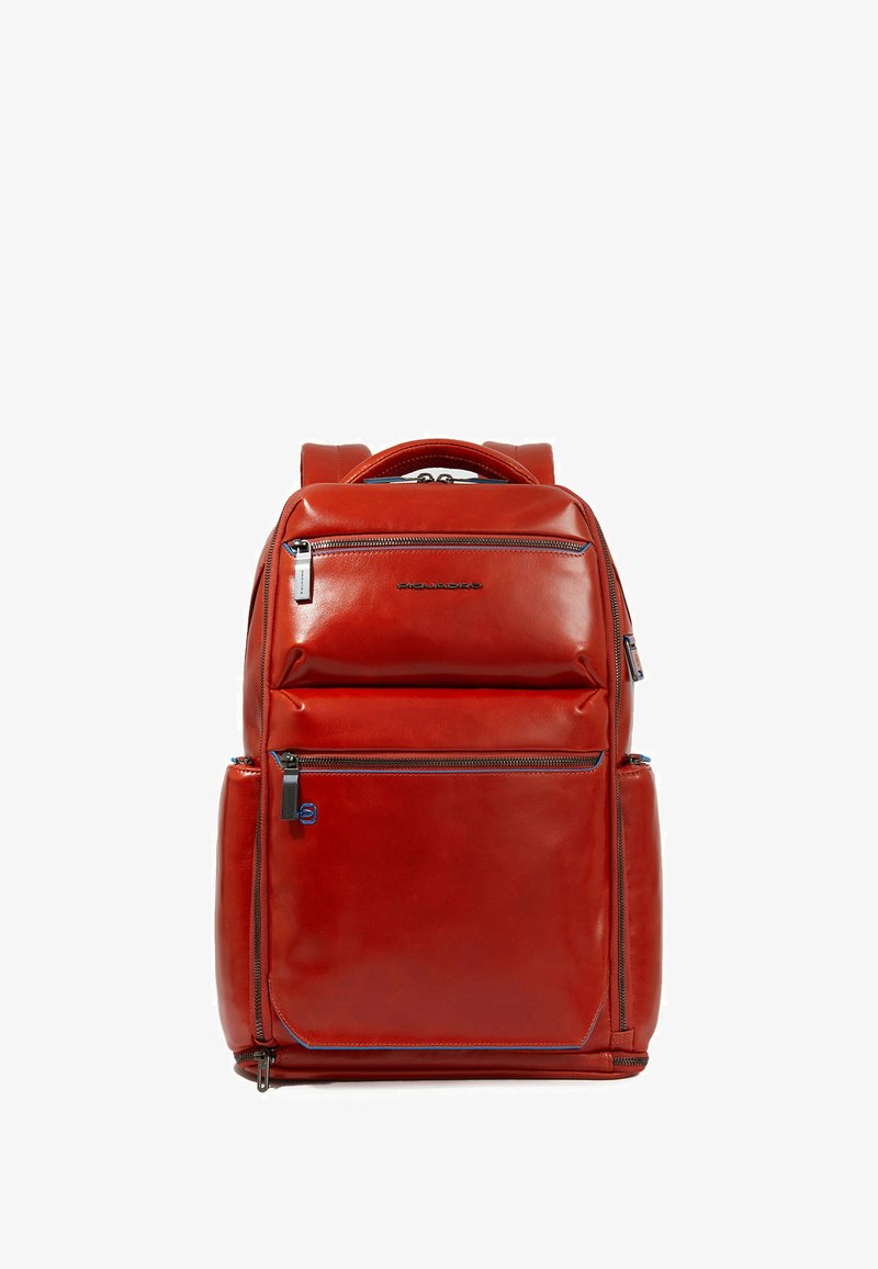 Zaino in pelle rossa con molteplici tasche con cerniera, texture liscia e dettagli contrastanti in blu. Dotato di maniglia superiore e spallacci imbottiti.